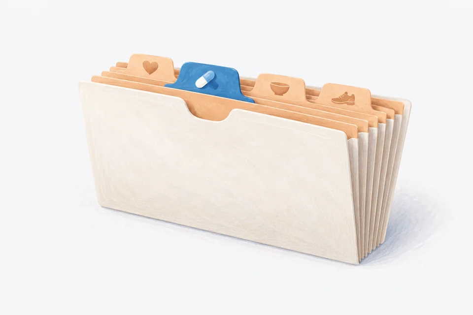 A blue medication tab projects from an accordion file with heart, meal and activity tabs.